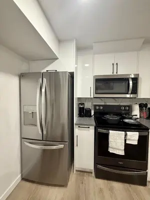 a kitchen with a stainless steel refrigerator and a microwave at Cozy 2 Bedroom Suite Close to Amenities in Edmonton