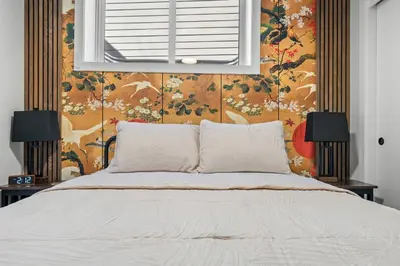 a bedroom with a bed and a floral wall at King Bed, Full Kitchen, Free Parking, Family Friendly Dining, Workspace & Fast Wi-fi - Private Basement Suite in Calgary
