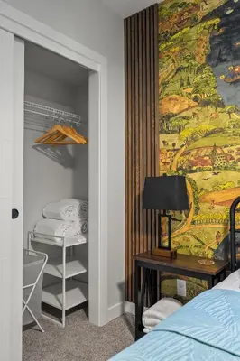a bedroom with two beds and a painting on the wall at King Bed, Full Kitchen, Free Parking, Family Friendly Dining, Workspace & Fast Wi-fi - Private Basement Suite in Calgary