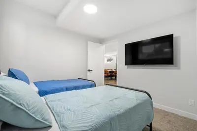 a living room with a couch and a flat screen tv at King Bed, Full Kitchen, Free Parking, Family Friendly Dining, Workspace & Fast Wi-fi - Private Basement Suite in Calgary