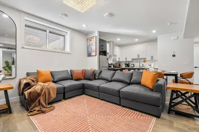 a living room with a couch and a kitchen at King Bed, Full Kitchen, Free Parking, Family Friendly Dining, Workspace & Fast Wi-fi - Private Basement Suite in Calgary