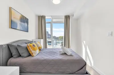 a bedroom with a bed and a large window at Parkside at Waterfront in Downtown Calgary in Calgary
