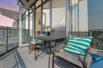 a balcony with a table and chairs and windows at Parkside at Waterfront in Downtown Calgary in Calgary