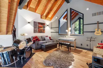 a living room with a couch drums and a table at Luxury Whistler 6BR Chalet, Hot Tub and Music Loft in Whistler