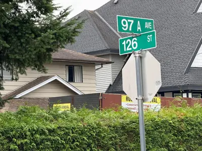 a street sign in front of a house at Downtown Central City Cozy Private 2 Bedroom Basement Suite - Independent Entry in Surrey