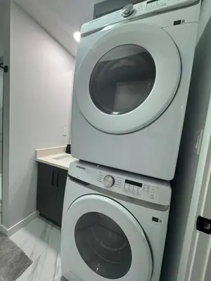 a white washing machine in a small bathroom at Modern comfort just 20 minutes from the airport, with a full kitchen in Edmonton
