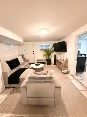a living room with a couch and a tv at Newly Renovated - Self contained Suite - Sleeps 6 in Vancouver