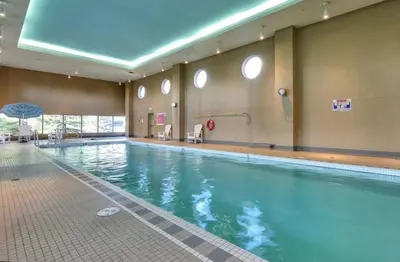 a large swimming pool in a building at The Spruce Modern 2BR Condo with Pool & Parking in Calgary
