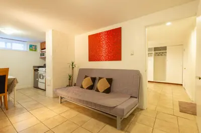 a living room with a couch and a red painting at South Vancouver Garden Home in Vancouver