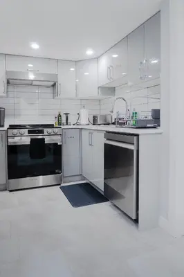 a kitchen with stainless steel appliances and white cabinets at Superior and Spacious 2-bedroom basement private suite in Edmonton