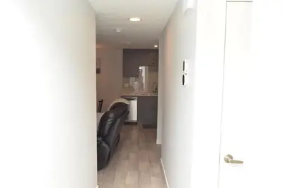 a living room with a couch and a kitchen at Beautiful Basement Suite in Stillwater, West Edmonton in Edmonton