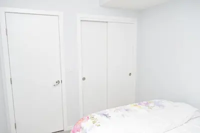 a bedroom with white cabinets and a bed at Beautiful Basement Suite in Stillwater, West Edmonton in Edmonton