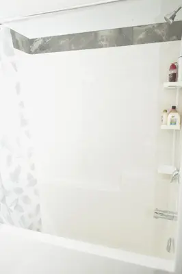 a white bathroom with a shower and a tub at Beautiful Basement Suite in Stillwater, West Edmonton in Edmonton