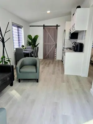 a living room with a door and a chair and a table at The Oasis in Stettler in Stettler