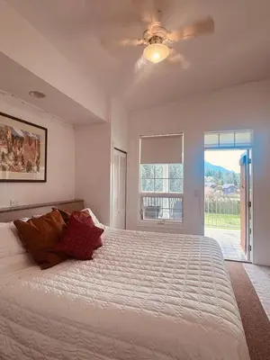 a bedroom with a large bed with a ceiling fan at Stunning Mountain View in Fairmont Hot Springs