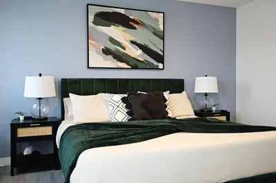 a bedroom with a large bed with two lamps at Chappelle with AC King Beds Fenced Yard Garage in Edmonton
