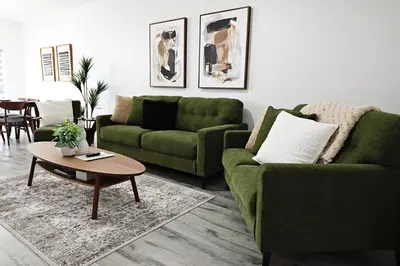 a living room with two green couches and a coffee table at Chappelle with AC King Beds Fenced Yard Garage in Edmonton