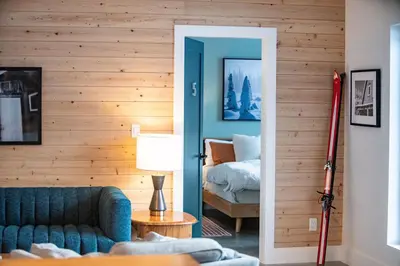 a living room with a blue couch and a bed at CAPOW House in Revelstoke
