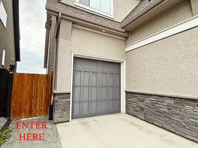 a house with a garage door on the side of it at Mahogany Lakefront 2BR Walkout Trails And Privacy in Calgary