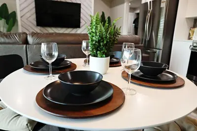 a table with black plates and wine glasses on it at Mahogany Lakefront 2BR Walkout Trails And Privacy in Calgary
