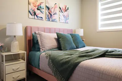 a bedroom with a bed with a green blanket at Edgemont Getaway King Bed Garage WEM And DisneyPlus in Edmonton