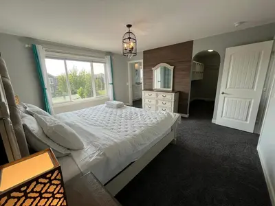 a bedroom with a large bed and a mirror at The Hidden Gem in Airdrie