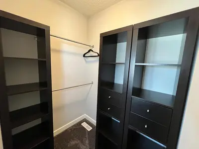 a closet with a black cabinet and shelves at The Hidden Gem in Airdrie