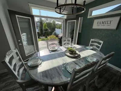 a dining room with a wooden table and chairs at The Hidden Gem in Airdrie