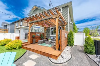 a wooden pergola in the backyard of a house at The Hidden Gem in Airdrie