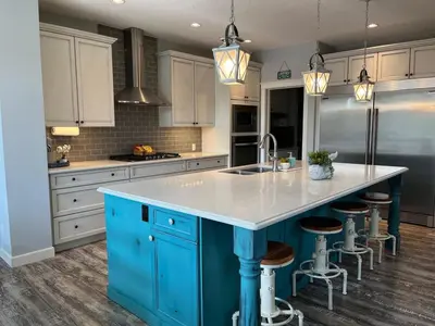 a kitchen with blue cabinets and a blue island with a sink at The Hidden Gem in Airdrie