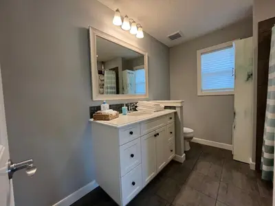 a bathroom with a white sink and a mirror at The Hidden Gem in Airdrie