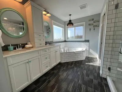 a bathroom with a tub and a sink and a mirror at The Hidden Gem in Airdrie