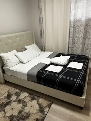 a bed with white pillows and a black blanket at Bedroom in the basement Upland 1 in Edmonton