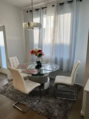 a dining room with a glass table and two chairs at Bedroom in the basement Upland 1 in Edmonton