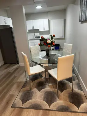 a dining room with a glass table and chairs at Bedroom in the basement Upland 1 in Edmonton
