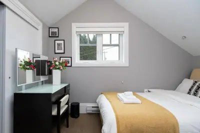 a bedroom with a bed and a desk and a window at Brand New Stylish 2 bedrooms Suite in Shaughnessy in Vancouver