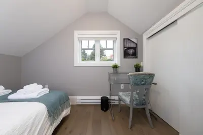 a bedroom with a bed and a desk and a chair at Brand New Stylish 2 bedrooms Suite in Shaughnessy in Vancouver