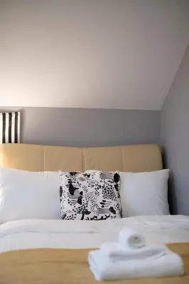a bed with a black and white pillow on it at Brand New Stylish 2 bedrooms Suite in Shaughnessy in Vancouver
