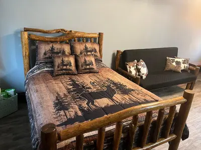 a bedroom with a wooden bed and a chair at Ellison Funny Farm in Barrière