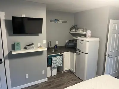 a kitchen with a refrigerator and a tv on the wall at Ellison Funny Farm in Barrière
