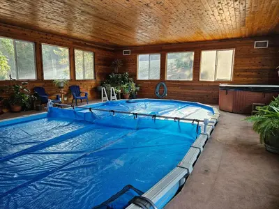 a large indoor swimming pool in a building with a large swimming pool at Ellison Funny Farm in Barrière