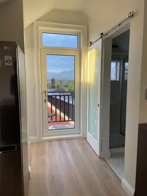 a room with a door with a view of a balcony at The Golden Sky Sanctuary at the Algonquin Residence in Prince Rupert