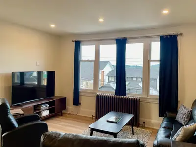a living room with a couch and a tv at The Golden Sky Sanctuary at the Algonquin Residence in Prince Rupert