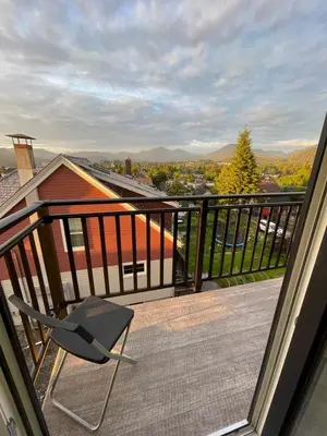 a chair sitting on a balcony with a view at The Golden Sky Sanctuary at the Algonquin Residence in Prince Rupert