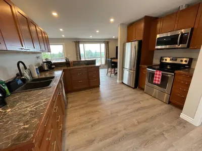 a kitchen with wooden cabinets and stainless steel appliances at 3 BR Serene Forest Sanctuary in Port Edward