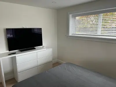 a living room with a flat screen tv on a white cabinet at 2BR Seaside Haven Retreat