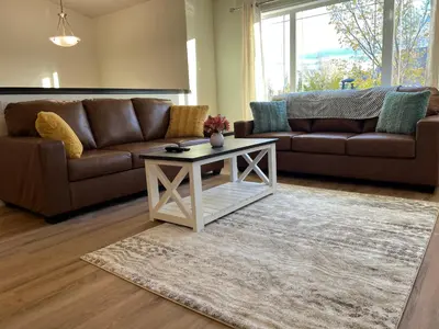 a living room with two couches and a coffee table at 3 Adjacent 4-bed Homes - Park Views, Fully Stocked in Grande Prairie