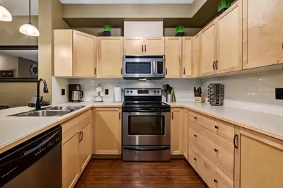 a kitchen with a stove and a microwave at Spacious Getaway near Banff with Heated Pool in Canmore