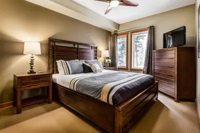 a bedroom with a large bed and a television at Spacious Getaway near Banff with Heated Pool in Canmore