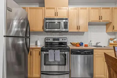 a kitchen with a stainless steel refrigerator and a microwave at Chic 1BR City Nest Heated Parking and Hot Tub and Pool in Canmore